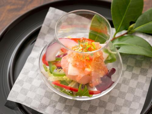 a salad in a glass bowl on a black plate at Takanosukan in Sekikawa