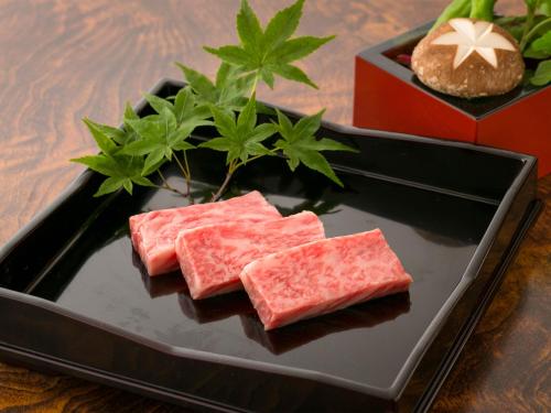 a black plate with three pieces of food on a table at Takanosukan in Sekikawa