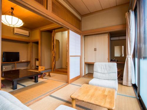 a living room with a couch and a table at Takanosukan in Sekikawa