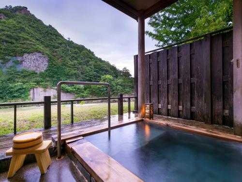 a plunge pool in a house with a bench and a stool at Takanosukan in Sekikawa