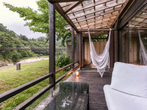 a screened in porch with a hammock on it at Takanosukan in Sekikawa