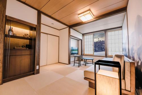 a japanese room with a table and chairs at SKI INN HAKUBA in Otari
