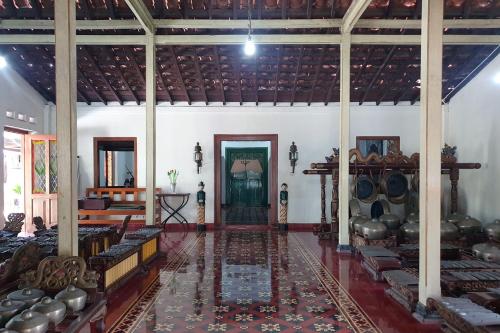 a large room with a door and a room with a rug at Omah Pitoe Yogya Homestay in Yogyakarta