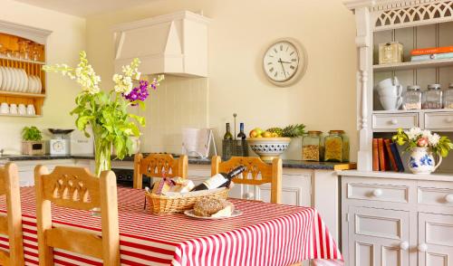 uma cozinha com uma mesa com uma toalha de mesa vermelha e branca em Courtyard Cottages em Tralee