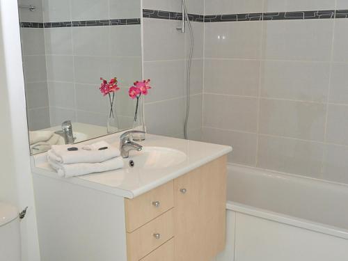 een badkamer met een wastafel en een bad met roze bloemen bij Appartement Flaine, 3 pièces, 8 personnes - FR-1-425-125 in Flaine