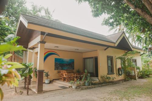 a small house with a rainbow painted on the side of it at Shenanigans Glamping Resort in Zamboanguita
