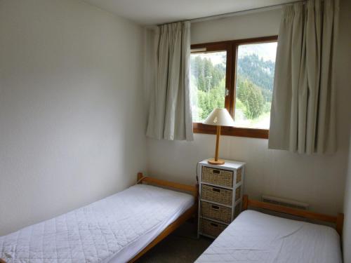 une chambre avec deux lits et une fenêtre dans l'établissement Appartement 3P rénové, balcon, proche pistes et commerces - FR-1-425-126, à Flaine