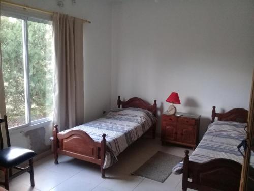 2 camas individuales en una habitación con ventana en Los Aguarybayes en La Banda