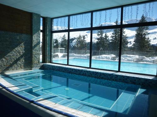 - une piscine dans une maison avec une grande fenêtre dans l'établissement Appartement 3 pièces avec cheminée, accès pistes, piscine, spa, WIFI - Flaine Montsoleil - FR-1-425-140, à Flaine