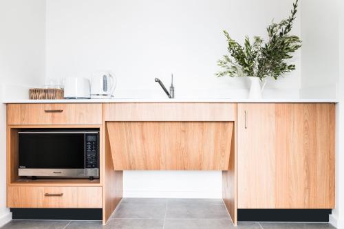 a kitchen with a sink and a microwave at The Ned Ryan Motel in Boorowa