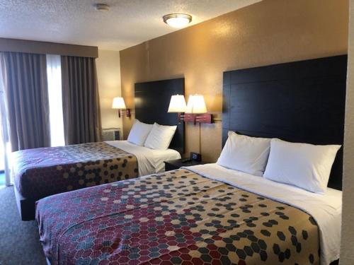 ein Hotelzimmer mit 2 Betten und 2 Lampen in der Unterkunft Rodeway Inn Flagstaff-Downtown in Flagstaff