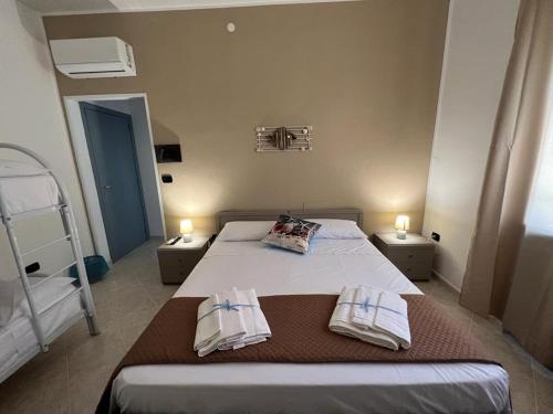 a bedroom with a bed with two towels on it at Ely Sea in Belvedere Marittimo