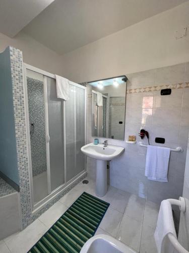 a white bathroom with a sink and a shower at Ely Sea in Belvedere Marittimo