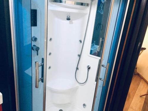 a shower in a bathroom with a glass door at Shenanigans Glamping Resort in Zamboanguita