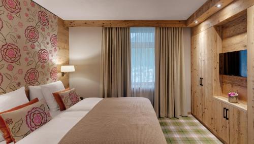 a hotel room with a large bed and a window at Morosani Schweizerhof in Davos