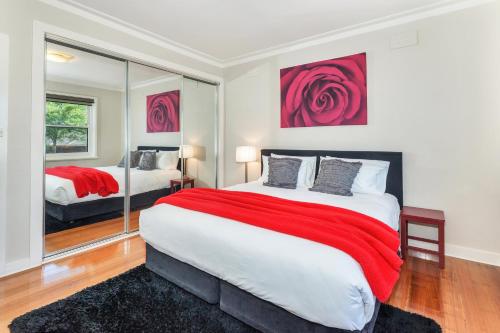 a bedroom with a large bed with a red blanket at Lake Wendouree Luxury Apartments in Ballarat