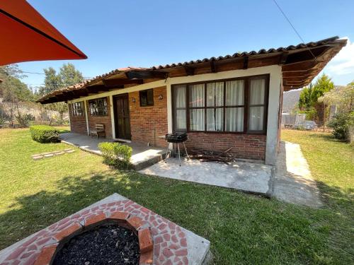 una pequeña casa de ladrillo con chimenea en el patio en Cabaña cerca del Santuario Valle de Bravo, en Valle de Bravo