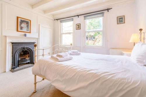 ein weißes Schlafzimmer mit einem Bett und einem Kamin in der Unterkunft The Anchorage in Whitby