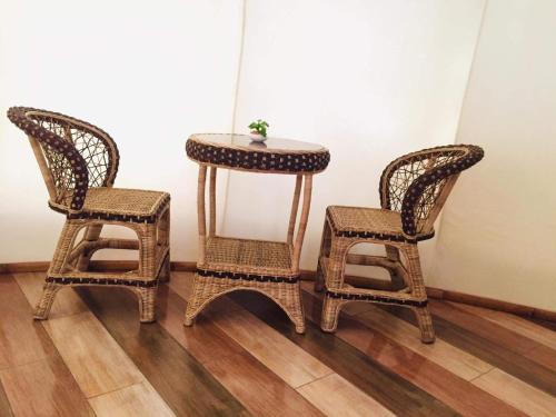 a table and two chairs and a table with a plant on it at Shenanigans Glamping Resort in Zamboanguita