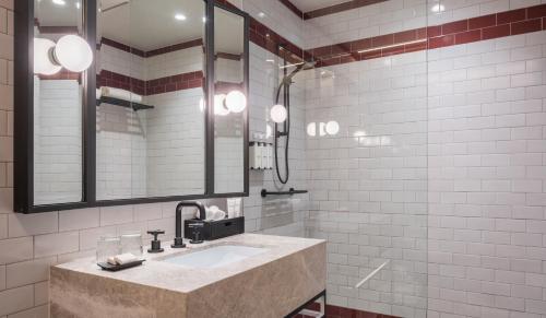 a bathroom with a sink and a mirror at Kimpton Margot Sydney by IHG in Sydney
