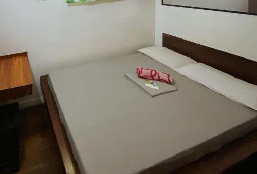 a small bedroom with a bed with a red object on it at RedDoorz @ Sukitel Budget Hotel Nasugbu in Nasugbu