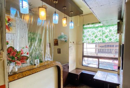a room with a table and a window and lights at RedDoorz @ Sukitel Budget Hotel Nasugbu in Nasugbu