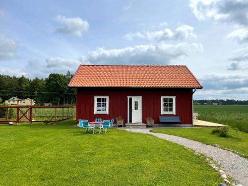 a red house with a table and chairs in the yard at 6 person holiday home in GÖTENE-By Traum in Götene