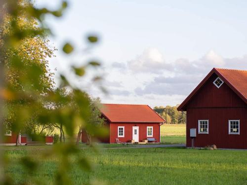 two red barns in a field with green grass at 6 person holiday home in GÖTENE-By Traum in Götene