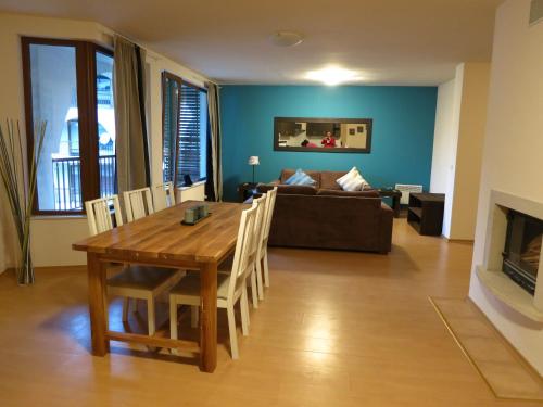 sala de estar con mesa de madera y sofá en Monastery Apartment C39, en Bansko