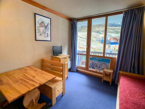 Cette chambre dispose d'une table en bois et d'une grande fenêtre. dans l'établissement Studio ski aux pieds avec balcon, accepte animaux - FR-1-502-342, à Tignes