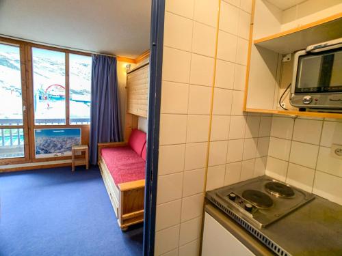 une cuisine avec cuisinière et une chambre avec canapé dans l'établissement Studio ski aux pieds avec balcon, accepte animaux - FR-1-502-342, à Tignes