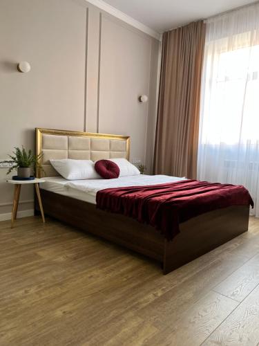 阿克套的住宿－Green Plaza - ЖК Грин Плаза，一间卧室配有一张带红色毯子的大床