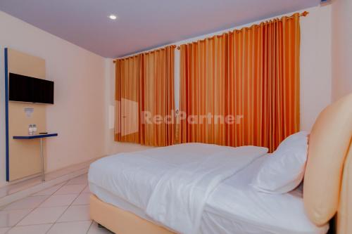 Tempat tidur dalam kamar di Ungu Kangen Hotel Bogor Mitra RedDoorz
