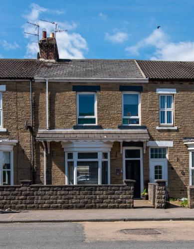 a brick house with blue windows on a street at The Old Nags Head in Bishop Auckland