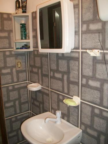 a bathroom with a sink and a tv on the wall at Casa da Jaca 02 in Itacaré