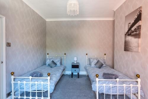 a bedroom with two beds and a chandelier at The Old Nags Head in Bishop Auckland
