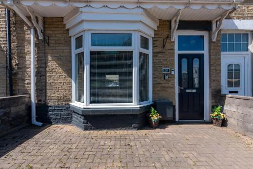 a house with a window and a door with two plants at The Old Nags Head in Bishop Auckland