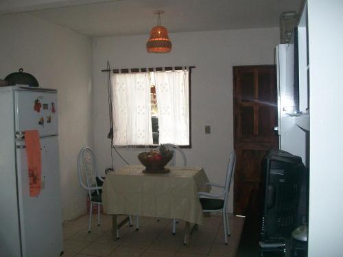 una mesa y sillas en una cocina con ventana en Casa da Jaca 02, en Itacaré