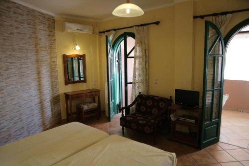 1 dormitorio con 1 cama, 1 silla y TV en The Harmony - Beachfront sea view apartment, en Agios Gordios