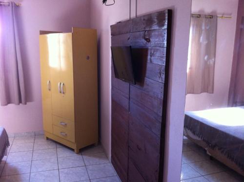a bedroom with a tv and a dresser with a bed at 50 Hotel in Extrema