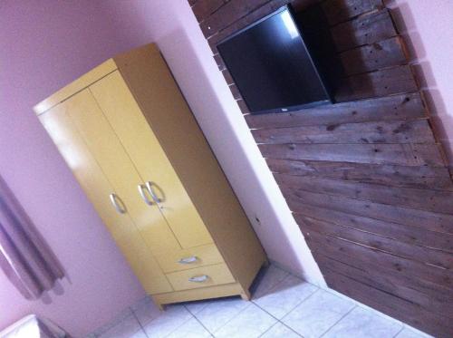 a room with a staircase with a cabinet and a tv at 50 Hotel in Extrema