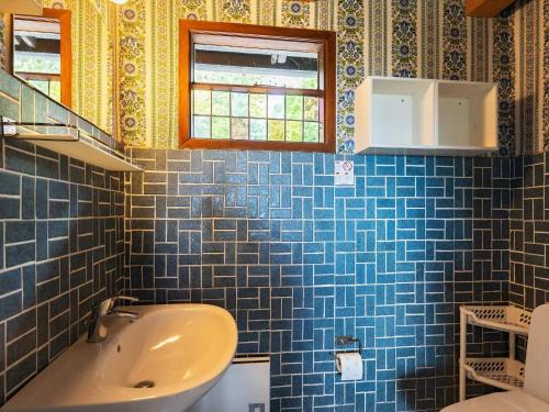 a blue tiled bathroom with a tub and a sink at 5 person holiday home in Roslev-By Traum in Sønder Thise