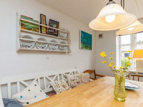 a dining room with a table and a vase with flowers at 6 person holiday home in Fur-By Traum in Fur