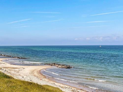 a beach with a bunch of rocks in the water at 6 person holiday home in Gilleleje-By Traum in Gilleleje