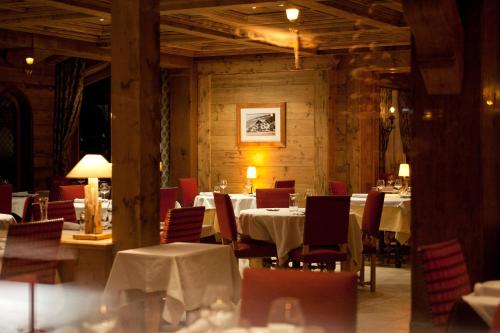 a dining room with tables and chairs with white table cloth at Hotel Le Samoyede in Morzine