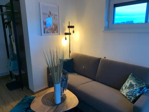 a living room with a couch and a table at Lieblingsplatzl - Das Apartmenthaus in Drobollach am Faakersee