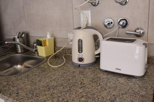 una tostadora sentada en un mostrador junto a un fregadero en Apart con Patio Exclusivo - Rosario Centro - Excelente - Cochera Opcional, en Rosario