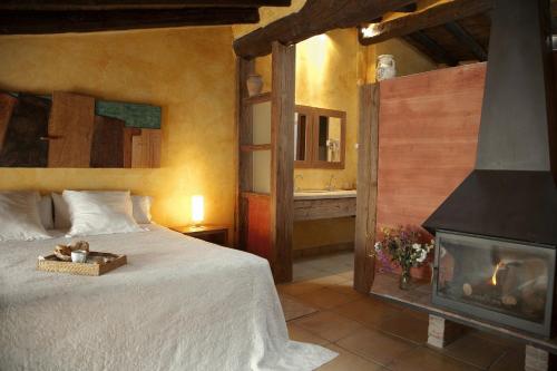 a bedroom with a bed and a fireplace at El Jardín Vertical in Vilafames