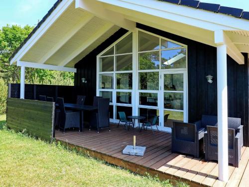 una terraza de madera con sillas y mesas en una casa en 10 person holiday home in Hadsund, en Hadsund