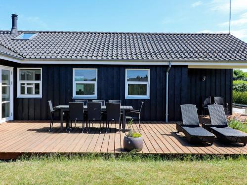 um deque com uma mesa e cadeiras e uma casa em 10 person holiday home in Hadsund em Hadsund